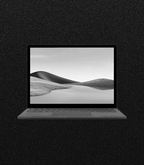 A laptop displaying a grayscale landscape of hills and water on its screen, set against a textured black background.